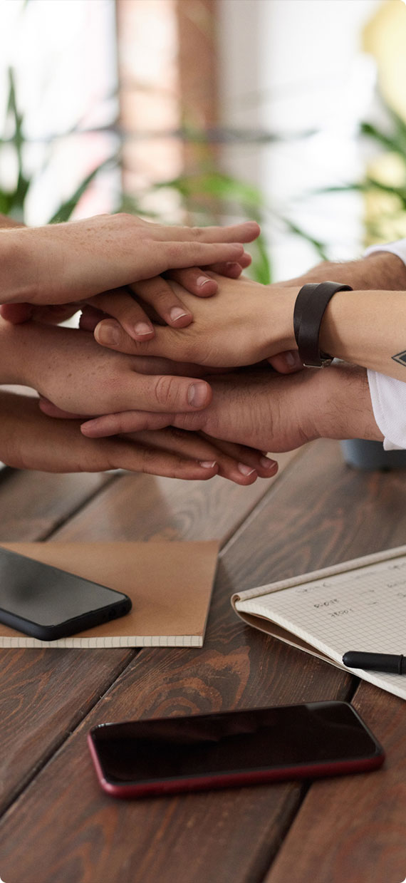 hands coming together in the middle of a table