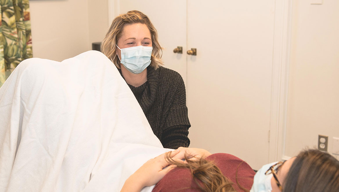 our-promise-img-update Physiotherapist talking to patient during treatment